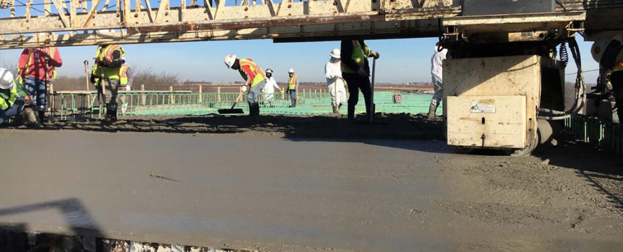 construction workers smoothing out concrete for Dallas Parkway